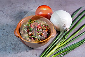 Foul Medames with tomato and garlic served in bowl isolated on grey background top view of bahrain food