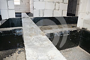 Foundation bitumen waterproofing. Building house construction with waterproofing spray-on tar