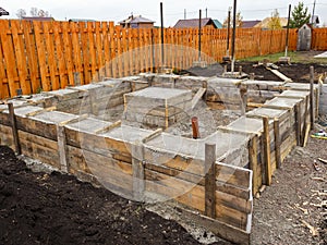 Foundation construction. Concrete is poured into a wooden formwork