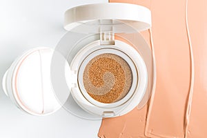 Foundation cushion with sponge and puff on white background.