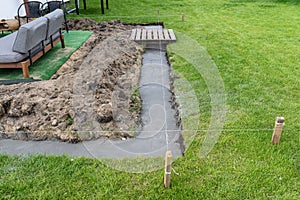 Foundation footings poured in a ditch in the yard, building a terrace in the backyard.