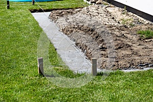 Foundation footings poured in a ditch in the yard, building a terrace in the backyard.