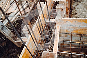 Foundation of house, building, details and reinforcements with steel bars and wire rod in wooden casings, preparing for