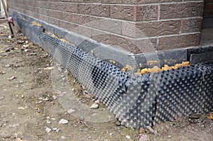 Foundation insulation with water proofing and damp proofing in problem corner area. House basement, foundation insulation details photo