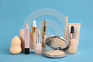 Foundation makeup products on light blue background. Decorative cosmetics