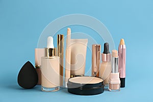 Foundation makeup products on light blue background. Decorative cosmetics