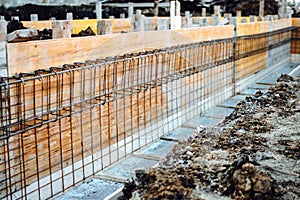 Foundation site of house, building, details and reinforcements with steel bars and wire rod in wooden casings, preparing for