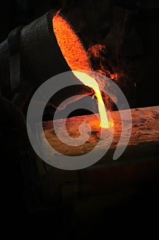 Foundry - molten metal poured from ladle into moul