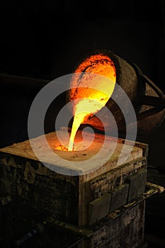 Foundry - molten metal poured from ladle into moul