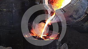 Foundry production. Workers pour metal from the bucket into special molds