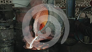 Foundry production. Workers pour metal from the bucket into special molds