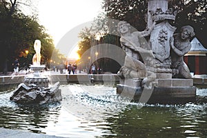 Fountain Alcachofa with sunset in background along path in park Retiro, Madrid, Spain photo