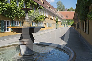 Fountain and apartments in the Fuggerei in Augsburg