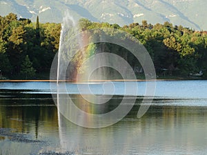 Fountain creating rainbow inside a lake. photo