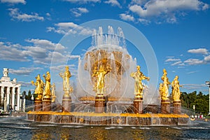A fountain with beautiful gilded figures of people on a bright sunny day.