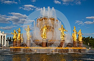 A fountain with beautiful gilded figures of people on a bright sunny day