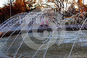 A fountain in the city park works and refreshes its coolness to passersby.