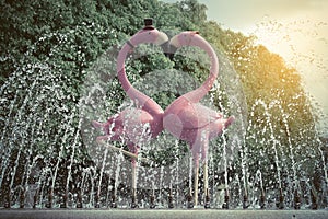 Fountain with a couple of lovely flamingos blue sky background