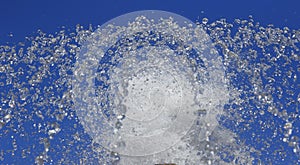 Fountain drops of pure water against a blue sky.