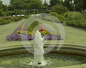 Fountain Flows In Front of Flowers