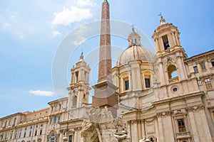 Fountain of the Four Rivers with an Egyptian obelisk and Sant Agnese Church on the famous Piazza Navona Square. Sunny summer day.