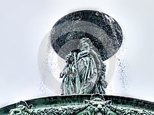 Fountain  in France with statues of people and water drops.