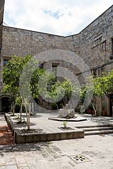 fountain inside old stone house surrounded by greenery, central courtyard, latin america