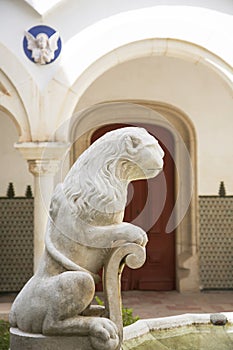 Fountain iwith a lion against an ancient architecture.