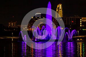 The Fountain and lake with light reflections at Night Heartland of America Park, Omaha Nebraska USA.