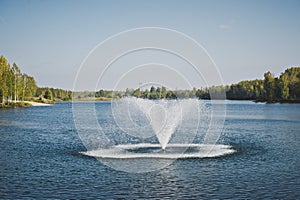 The fountain in the middle of the pond .