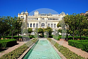 Fountain in the Pedro Luis Alonso gardens with the city hall to the rear, Malaga, Spain.
