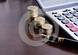 Fountain pen and Money coins stack and calculator for finance co