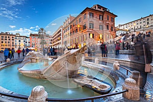 Fountain on the Piazza di Spagna square and the Spanish Steps in Rome at dusk, Italy