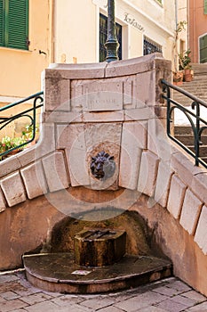 Fountain on Place du Conseil in Villefranche-sur-Mer on the Cote d`Azur. A jet of water flows from the lion`s mouth.