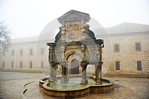 Fountain of Saint Mary -Santa Maria- and st. Philip seminary a foggy day in Baeza. Spain