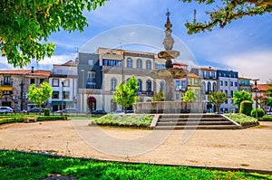 Fountain in small park and typical colorful buildings houses on Campo das Hortas square in Braga city