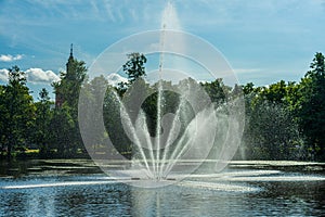 Fountain squirting water in bright summer sunlight