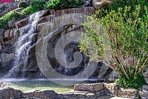 Fountain stylized as a waterfall from a cliff on the embankment of  Alanya Marina Yat Limani Turkey. Water streams falling from