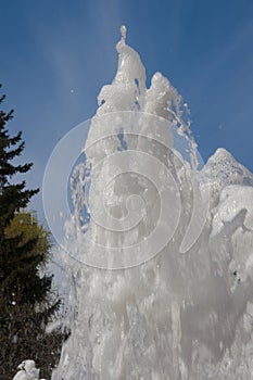 Fountain water jet close up on blue sky background