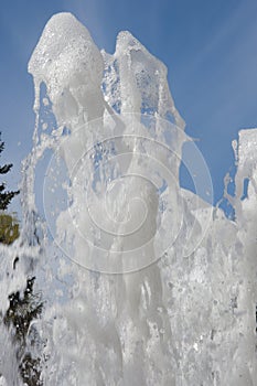 Fountain water jet close up on blue sky background