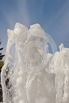 Fountain water jet close up on blue sky background