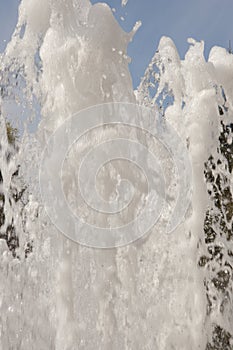 Fountain water jet close up on blue sky background