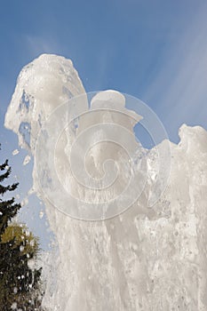 Fountain water jet close up on blue sky background