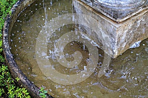 Fountain water stream splashing in the middle of the old marketplace. An old classic style stone