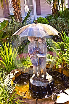 Fountain with water from an umbrella with kids