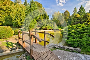 Fountain and wooden bridge in small lake in the park in Sliac spa resort