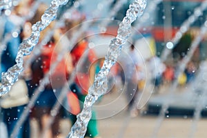 Spray fountain in the city center with selective focus and blurred background. Image of a water jet in a fountain