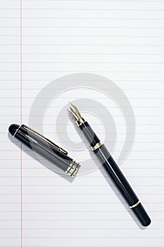 Fountain writing pen on blank lined paper background