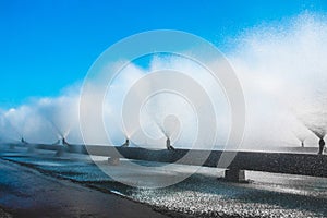 Fountains from a system of pipes cooling water at a thermal power plant. Splashing fountain against blue sky in industrial area