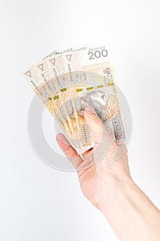 Four 200 PLN banknotes held in right hand